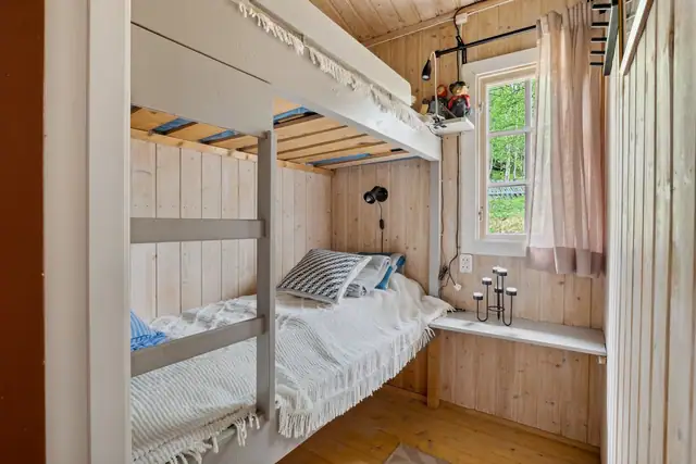 Ett av soverommene i hoveddelen er innredet med plassbygde køyesenger.