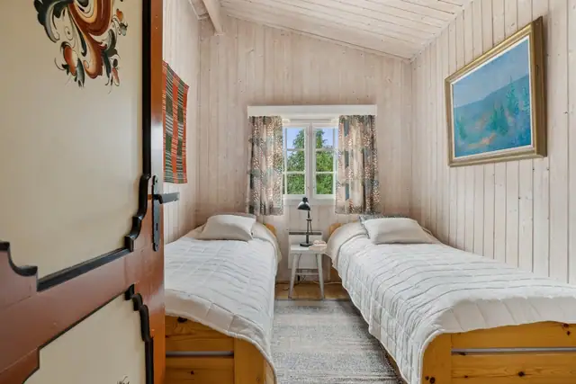 Det nest største soverommet i hoveddelen har plass til to senger. Legg merke til den fine rosemalingen på døren.