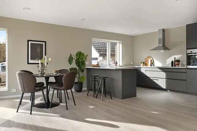 Kjøkken fra Drømmekjøkkenet med integrerte hvitevarer og åpen forbindelse til spiseplassen.