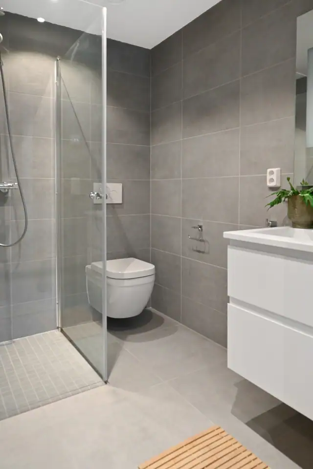 Baderommet leveres med hvit innredning, speil med lys og vegghengt toalett med soft-close.