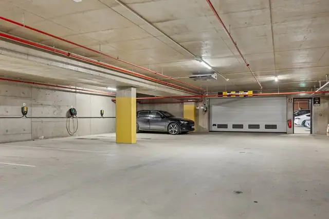 Parkeringsplass med elbil lader i kjeller følger handelen.