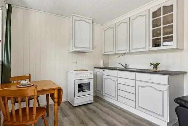 Kjøkken med komfyr og vifte, samt vask som er tilkoblet privat avløpstank (gråvann).