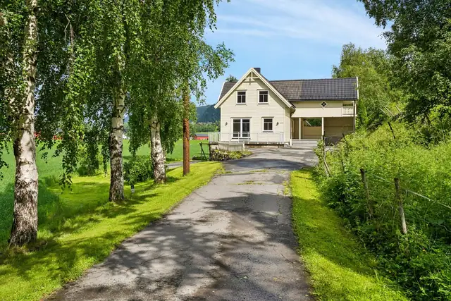 En usjenert eiendom, omgitt av flotte grøntarealer.