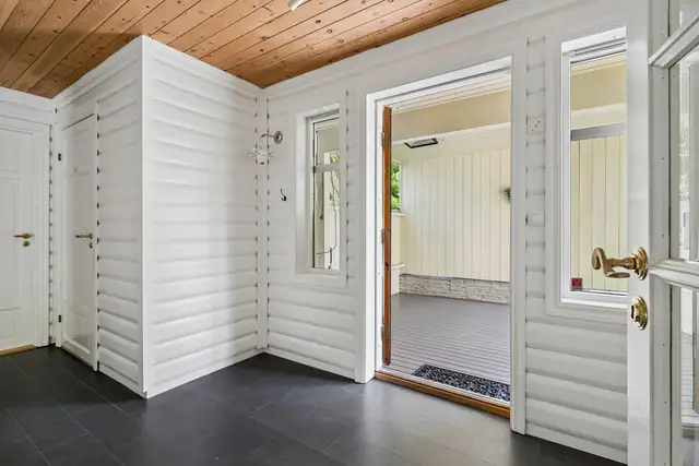 Velkommen inn! Entreen har flislagt gulv, og hvitbeiset trevegger i god stand.