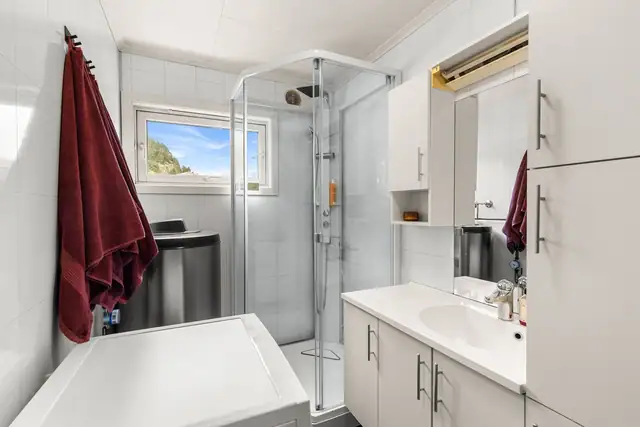 Badet inneholder bl.a. dusjkabinett, tidløs innredning med god plass til hygieneartikler, servant og toalett. Badet er på 4 kvm.
