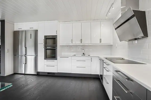Moderne, stilren innredning med integrerte hvitevarer.
