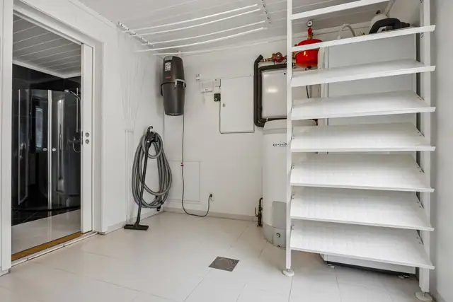 Vaskerommet har en funksjonell utforming med god plass til klesvask og oppbevaring. Her finner man sentralen til både sentralstøvsuger og vannbåren varme.