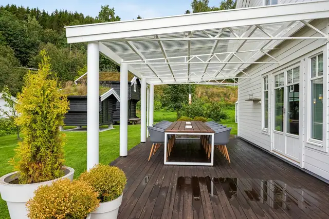 Overbygget terrasse i stål gir en lun og anvendelig uteplass med lite vedlikehold.
