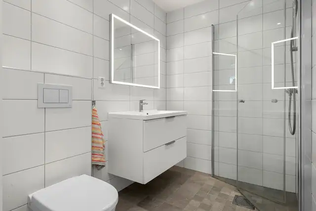 Badet er innredet med dusj, servantinnredning og toalett.