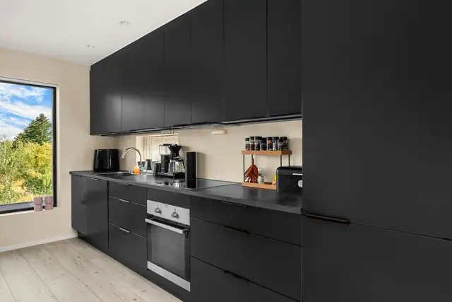 Kjøkkenet fremstår moderne og stilrent, med god plass til matlaging og oppbevaring.