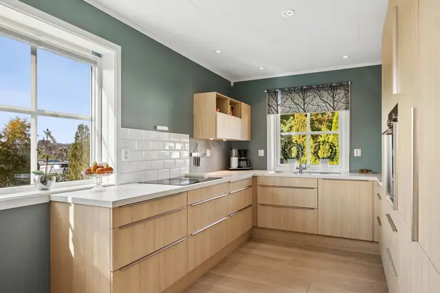 Fra kjøkkenkroken har du fin utsikt mot hagen - en flott detalj som knytter innendørs og utendørs liv tett sammen.