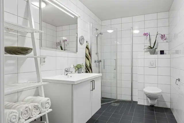 Pent og delvis nyere inntrykk, med flislagte vegger, gulvvarme og dusjhjørne med dører. Vegghengt toalett og servantinnredning med speil og overlys gir et lyst og ryddig bad. Opplegg for vaskemaskin er på plass.